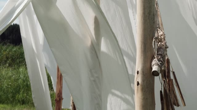 Paño-de-lino-blanco-y-atrapasueños-étnicos-en-postes-de-madera-columpios-en-el-viento.
