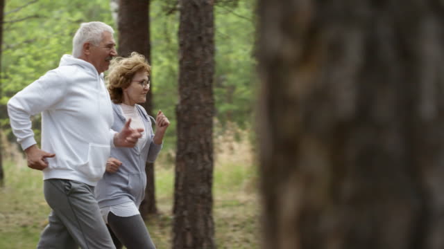 Anciano-alegre-y-mujer-para-correr-en-el-bosque