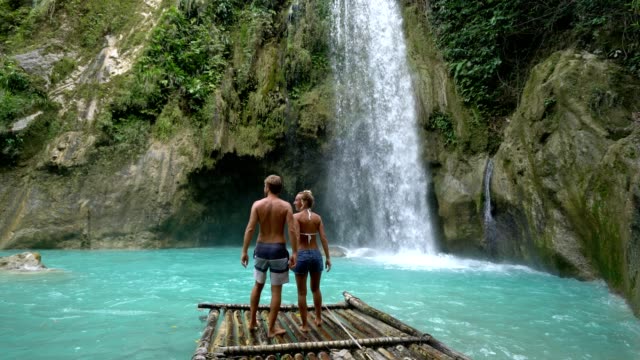 Pareja-joven-siendo-cariñoso-en-hermosa-cascada-tropical-en-Filipinas-disfrutando-vacaciones-y-libertad.-Concepto-de-amor-la-gente-viaja