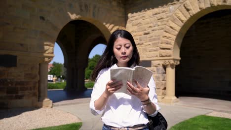 Schüler,-die-während-des-Gehens-auf-sonnigen-Tag-lesen