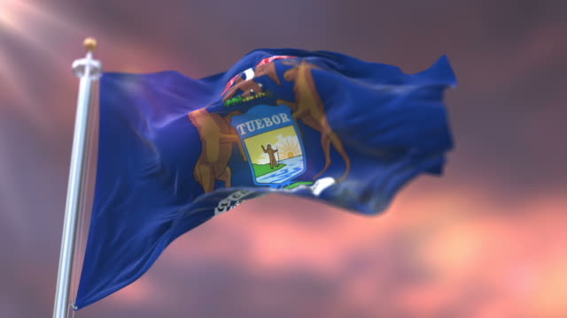 Flag-of-american-state-of-Michigan-at-sunset,-region-of-the-United-States---loop