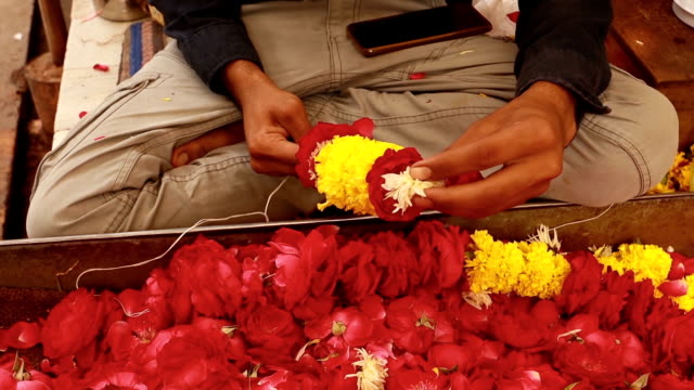 En-la-India,-donde-las-guirnaldas-de-flores-tienen-un-papel-importante-y-tradicional-en-cada-festival,-las-deidades-hindúes-están-decoradas-con-guirnaldas-hechas-de-diferentes-flores-fragantes-(a-menudo-jazmín)-y-hojas.