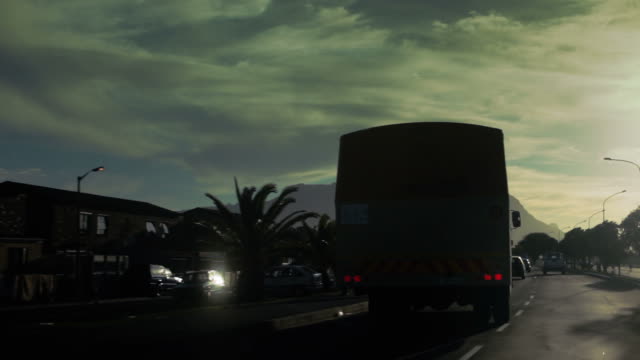 Siguientes-Cape-Town-autobús-por-la-calle-principal-y-en-la-puesta-de-sol