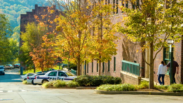 Von-Bäumen-gesäumten-Straße-im-Herbst-in-Asheville,-NC,-City-Polizei