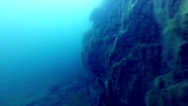 Freediver-explorar-un-lado-de-un-submarino-del-acantilado-en-una-cantera