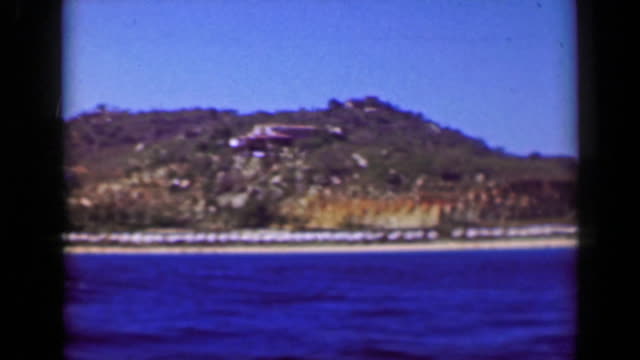 1952:-paseo-en-barco-de-lujo-con-vista-al-mar-acantilado-tropicales-ricas-casas-de-mansiones-villas.