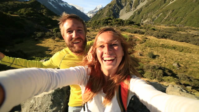 Young-couple-take-self-portrait-on-mountain-background