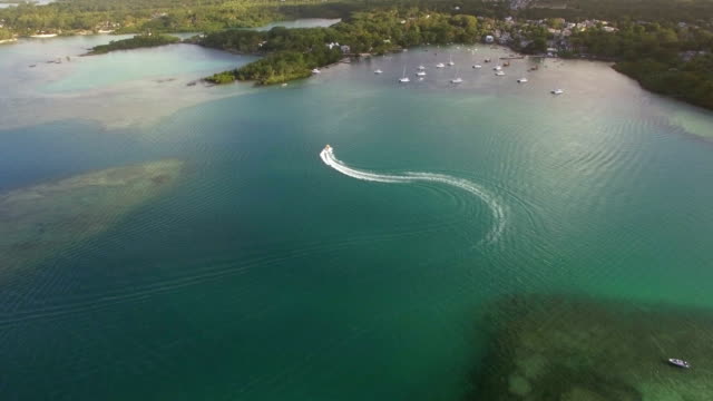 Flying-over-motor-boat-sailing-in-bay,-Mauritius-Island