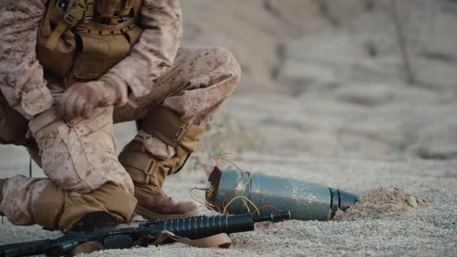 Soldat-entschärfung-einer-Bombe-durch-Schneiden-eines-Drahtes-während-der-Militäroperation-in-Wüstenumgebung