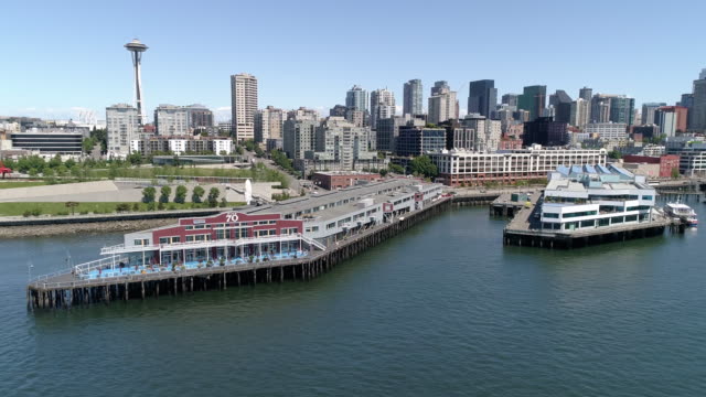 Aerial-Dolly-Across-Downtown-Seattle-Buildings-and-Waterfront-Pier-70-on-Sunny-Day-with-Blue-Sky