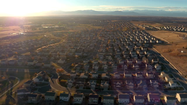 AERIAL:-Row-houses-in-suburban-town-in-valley-surrounded-by-mountains-at-sunrise