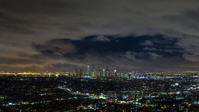 Skyline-del-centro-de-Los-Angeles-por-la-noche-con-Timelapse-de-nubes