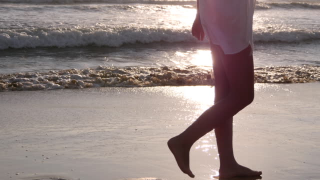 Mujer-caminando-en-la-playa-cerca-del-océano.-Joven-hermosa-chica-disfrutando-de-la-vida-y-va-en-el-mar-costa.-Vacaciones-de-verano-o-vacaciones.-Paisaje-marino-en-el-fondo.-Vista-posterior-posterior