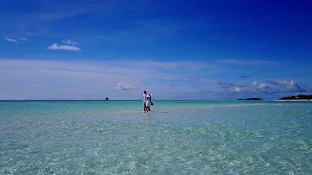 v03937-fliegenden-Drohne-Luftaufnahme-der-Malediven-weißen-Sandstrand-2-Personen-junges-Paar-Mann-Frau-romantische-Liebe-auf-sonnigen-tropischen-Inselparadies-mit-Aqua-blau-Himmel-Meer-Wasser-Ozean-4k