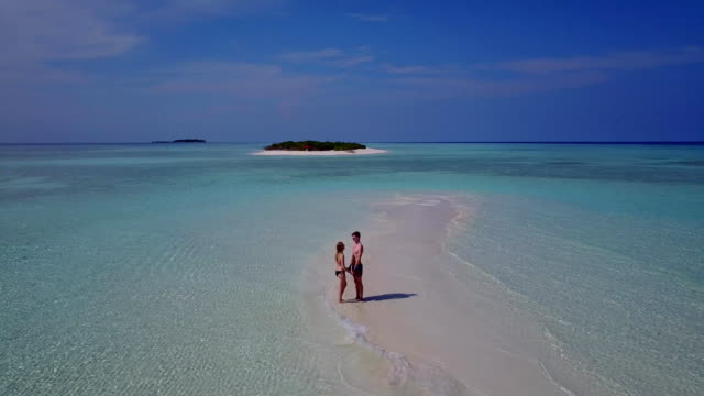 v03899-fliegenden-Drohne-Luftaufnahme-der-Malediven-weißen-Sandstrand-2-Personen-junges-Paar-Mann-Frau-romantische-Liebe-auf-sonnigen-tropischen-Inselparadies-mit-Aqua-blau-Himmel-Meer-Wasser-Ozean-4k