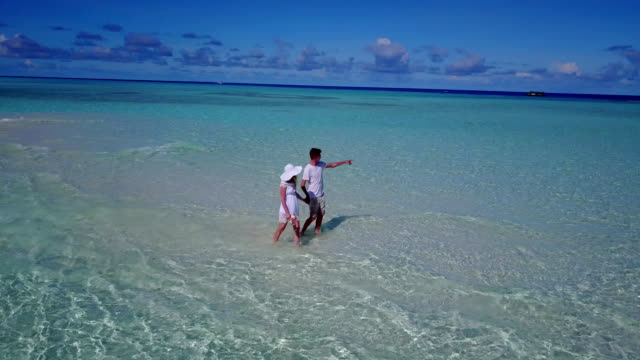 v03922-fliegenden-Drohne-Luftaufnahme-der-Malediven-weißen-Sandstrand-2-Personen-junges-Paar-Mann-Frau-romantische-Liebe-auf-sonnigen-tropischen-Inselparadies-mit-Aqua-blau-Himmel-Meer-Wasser-Ozean-4k