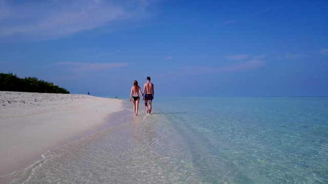 v03864-fliegenden-Drohne-Luftaufnahme-der-Malediven-weißen-Sandstrand-2-Personen-junges-Paar-Mann-Frau-romantische-Liebe-auf-sonnigen-tropischen-Inselparadies-mit-Aqua-blau-Himmel-Meer-Wasser-Ozean-4k