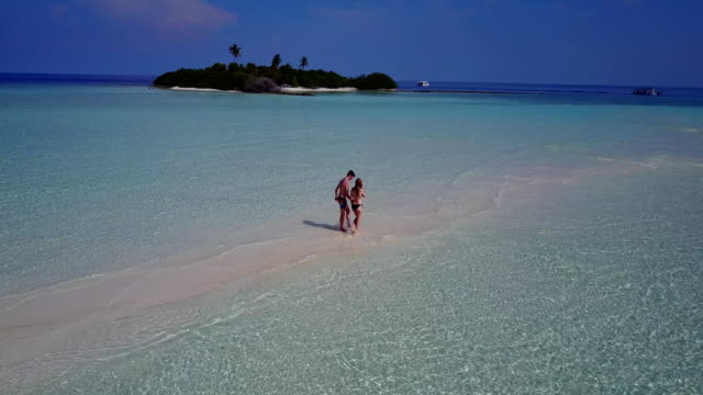 v04027-fliegenden-Drohne-Luftaufnahme-der-Malediven-weißen-Sandstrand-2-Personen-junges-Paar-Mann-Frau-romantische-Liebe-auf-sonnigen-tropischen-Inselparadies-mit-Aqua-blau-Himmel-Meer-Wasser-Ozean-4k