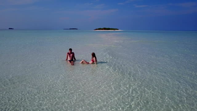 v04029-fliegenden-Drohne-Luftaufnahme-der-Malediven-weißen-Sandstrand-2-Personen-junges-Paar-Mann-Frau-romantische-Liebe-auf-sonnigen-tropischen-Inselparadies-mit-Aqua-blau-Himmel-Meer-Wasser-Ozean-4k