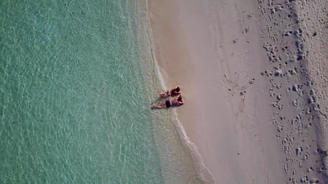 v04022-fliegenden-Drohne-Luftaufnahme-der-Malediven-weißen-Sandstrand-2-Personen-junges-Paar-Mann-Frau-romantische-Liebe-auf-sonnigen-tropischen-Inselparadies-mit-Aqua-blau-Himmel-Meer-Wasser-Ozean-4k