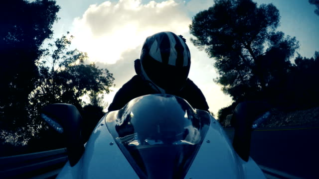 POv-shot-of-a-man-riding-on-a-white-sports-motorcycle-on-a-curved-road