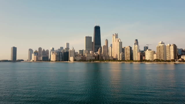 Vista-aérea-del-lago-Michigan-y-Chicago,-América.-Drone-volando-bajo-sobre-el-agua-el-centro-de-la-ciudad-en-la-mañana