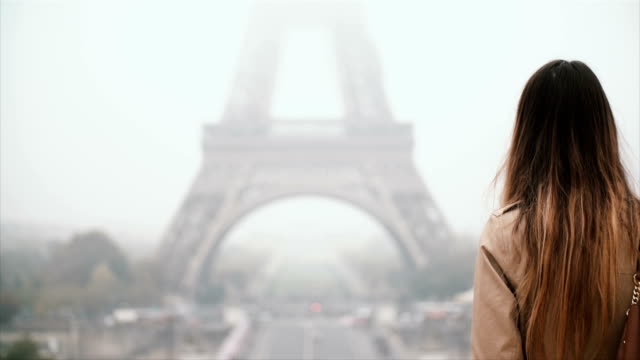 Vista-posterior-de-elegante-joven-de-pie-delante-de-la-Torre-Eiffel-y-si-a-la-vista-famosa-París,-Francia