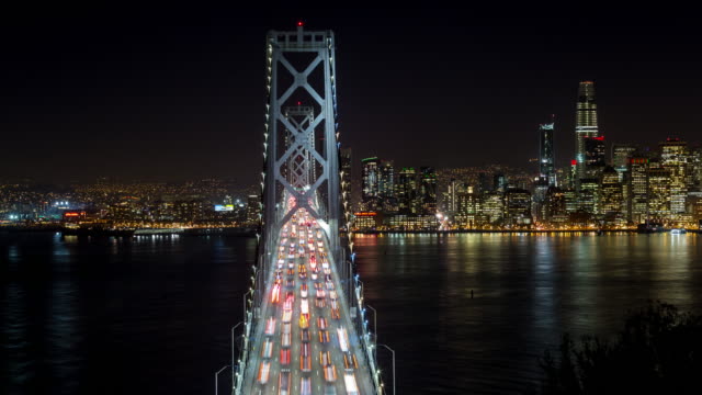 Oakland-Bay-Bridge-de-San-Francisco-y-el-centro-en-el-lapso-de-tiempo-de-noche