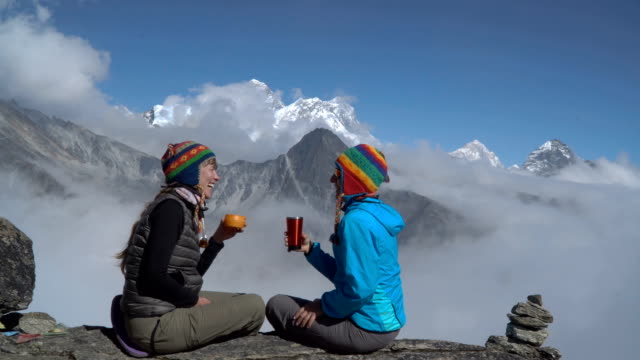 Dos-chicas-están-bebiendo-té-en-las-montañas