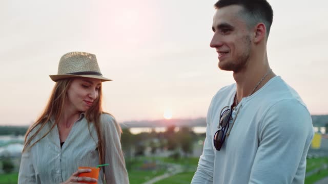 Two-young-students-people-dancing-and-enjoying-sunset-at-summer-rooftop-party