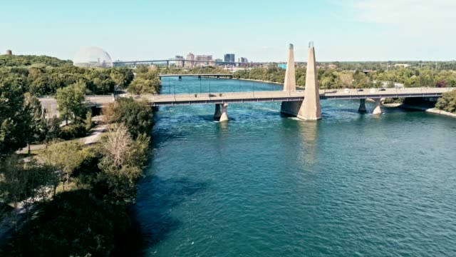 aerial-drone-footage-of-montreal-with-bridges-and-a-park-area-plus-ile-sainte-helene-island-with-the-biosphere-dome-in-the-background