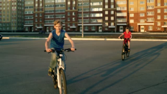Jungen-und-Mädchen-reitet-auf-Bikea-und-Roller-Rollen-direkt-an-der-Kamera