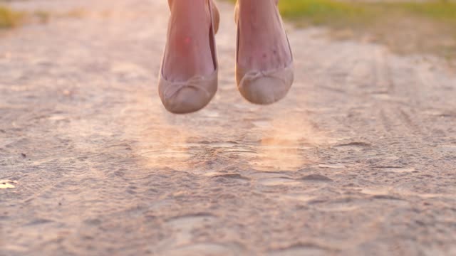 Woman-feet-in-flat-shoes-jump-in-road-dust.