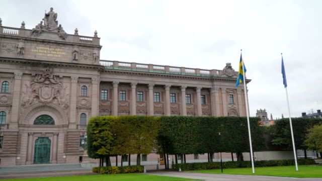 Zwei-Fahnen-auf-den-Pol-außerhalb-des-nationalen-Gesetzgebers-Gebäude-in-Stockholm-Schweden