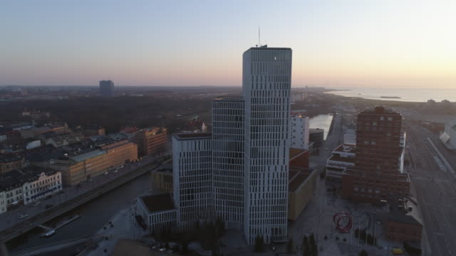 Vista-aérea-de-rascacielos-moderno-edificio-de-oficinas-en-la-ciudad-de-Malmö,-Suecia.-Tiro-de-Drone-volando-alrededor-de-los-edificios-de-negocios-en-el-distrito-financiero-al-atardecer.-Calle,-canal-y-horizonte-de-paisaje-urbano-centro
