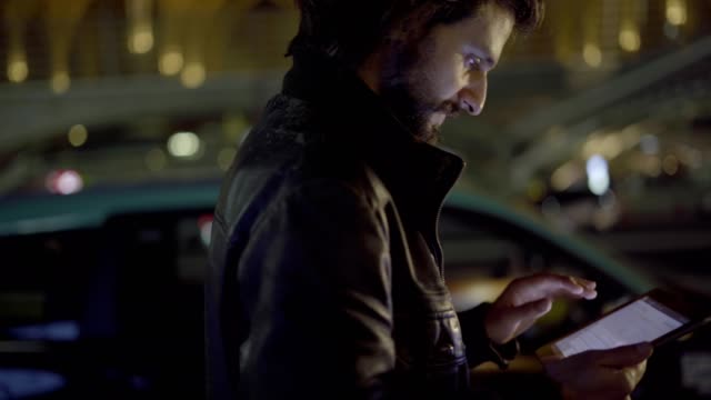 Kaukasischen-Mann-SMS-auf-Tablet-während-des-Gehens-auf-Straße-in-der-Nacht