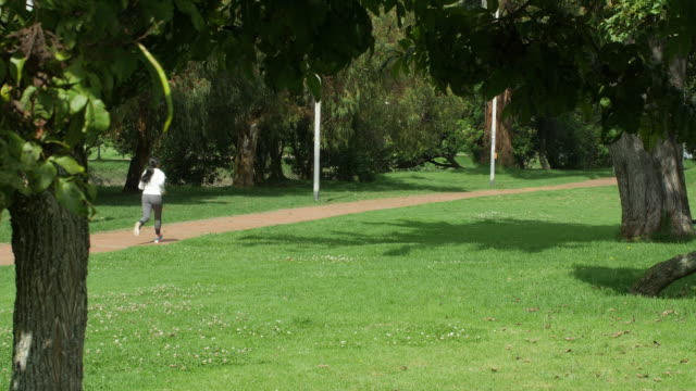 Woman-jogging-in-lush-city-park-in-Bogotá,-Colombia