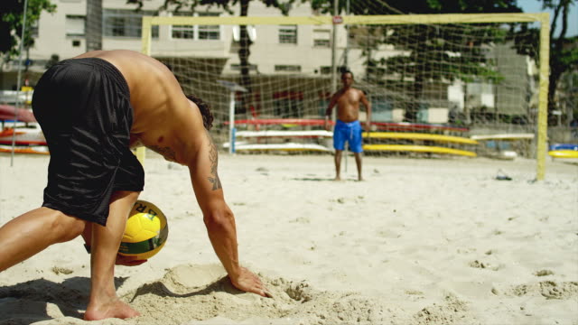 Friends-practice-kicking-a-goal-on-a-beach-in-Brazil.
