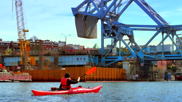 4K-Woman-Paddles-her-Kayak-up-to-the-Johnson-Street-Bridge-in-Victoria-BC