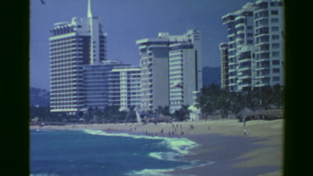 1978:-Hoteles-de-gran-altura-frente-a-turismo-popular-rompiendo-olas-playa.