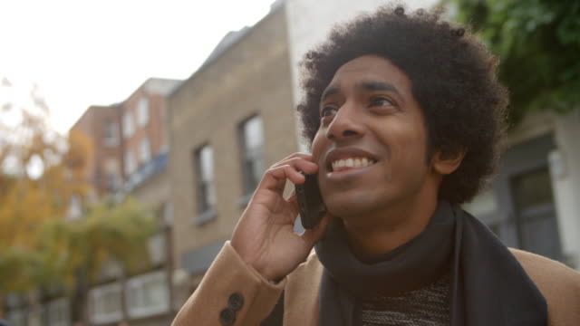 Stilvolle-junge-Mann-Telefonanruf-tätigen-auf-Stadtstraße