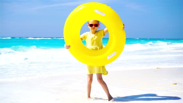 Kleines-Mädchen-mit-aufblasbaren-Kautschuk-Kreis-auf-Strandurlaub