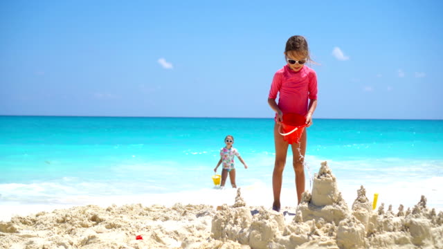 Happy-little-kids-playing-with-beach-toys-during-tropical-vacation