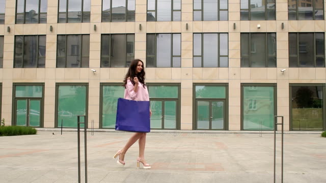 Girl-comes-with-a-blue-bag-near-modern-building.