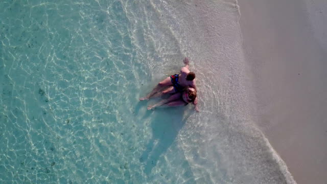 v03875-fliegenden-Drohne-Luftaufnahme-der-Malediven-weißen-Sandstrand-2-Personen-junges-Paar-Mann-Frau-romantische-Liebe-auf-sonnigen-tropischen-Inselparadies-mit-Aqua-blau-Himmel-Meer-Wasser-Ozean-4k