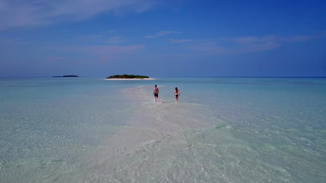 v03888-fliegenden-Drohne-Luftaufnahme-der-Malediven-weißen-Sandstrand-2-Personen-junges-Paar-Mann-Frau-romantische-Liebe-auf-sonnigen-tropischen-Inselparadies-mit-Aqua-blau-Himmel-Meer-Wasser-Ozean-4k