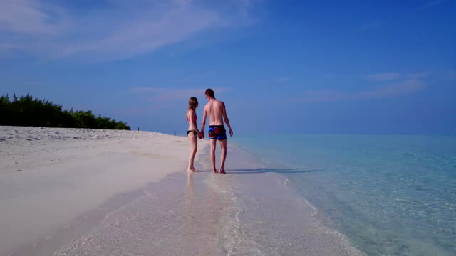 v03963-fliegenden-Drohne-Luftaufnahme-der-Malediven-weißen-Sandstrand-2-Personen-junges-Paar-Mann-Frau-romantische-Liebe-auf-sonnigen-tropischen-Inselparadies-mit-Aqua-blau-Himmel-Meer-Wasser-Ozean-4k
