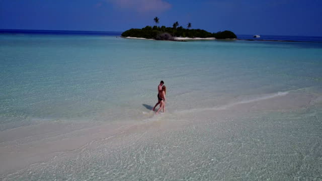 v03882-fliegenden-Drohne-Luftaufnahme-der-Malediven-weißen-Sandstrand-2-Personen-junges-Paar-Mann-Frau-romantische-Liebe-auf-sonnigen-tropischen-Inselparadies-mit-Aqua-blau-Himmel-Meer-Wasser-Ozean-4k