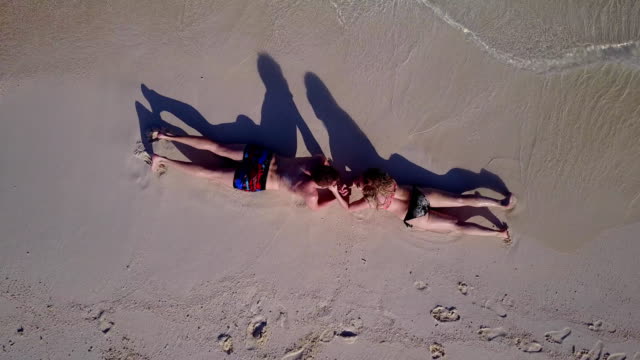 v03889-fliegenden-Drohne-Luftaufnahme-der-Malediven-weißen-Sandstrand-2-Personen-junges-Paar-Mann-Frau-romantische-Liebe-auf-sonnigen-tropischen-Inselparadies-mit-Aqua-blau-Himmel-Meer-Wasser-Ozean-4k