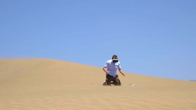 Video-de-hombre-explorando-la-realidad-virtual-en-el-desierto-en-4k